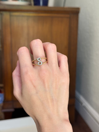 Diamond initial S ring worn on a hand to show its size.