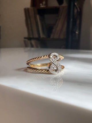 Diamond initial S ring showing the letter and braided gold shoulders.