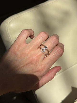 Diamond initial S ring with gold braided shoulders worn on a hand.