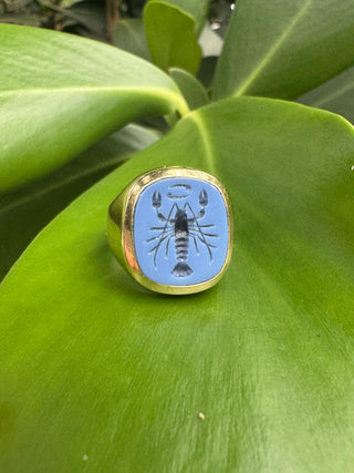 Front view of a blue chalcedony intaglio ring showing its carved motif.