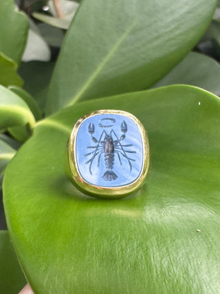 Close-up of the carved blue chalcedony face of an intaglio ring.