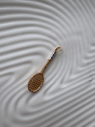 Back view of a gold tennis racket pendant.